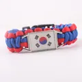 Dettaglio del charm bandiera sudcoreana su bracciale in paracord intrecciato rosso e blu. - Stile Paracord Rettangolare