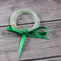Vista detallada de pulseras de gelatina verde claro de tres capas con lazo de cinta de seda - Agosto Verde Claro