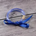 Detalle de tres brazaletes de gelatina con purpurina azul y lazo de cinta azul. - Septiembre Azul Oscuro