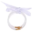Detail shot of five glittery silicone jelly bangles tied with a white satin bow. - April