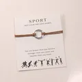 Κοντινό πλάνο του βραχιολιού Sport με χαραγμένο ασημένιο δαχτυλίδι DANCE σε κάρτα - Καφέ