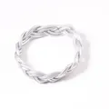 Vue rapprochée d'un bracelet en PVC tressé argenté montrant la texture torsadée - Argent