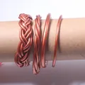 Detailed view of 4 copper-toned jelly bangles featuring braided and smooth designs. - Set of 4 / Rose Gold