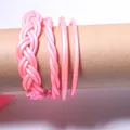 Close-up detail of pink PVC silicone braided jelly bangles four-piece set on a prop - Set of 4 / Pink