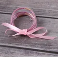Set of 7 pink silicone glitter jelly bangles tied with a soft pink ribbon bow accessory - Pink