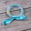 Brazaletes de silicona azul de tres capas con pedrería brillante y cinta de raso a juego. - Diciembre Azul Cielo