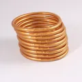 Set mit neun flexiblen goldfarbenen PVC-Glitzerarmbändern für stilvolle Frauen - 9er Set / Altgold