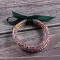 Set of five colorful silicone seed bead bracelets featuring a decorative dark green ribbon - 5 Pieces / Mixed Dark Green