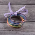 Seven layers of colorful silicone glitter jelly bangles tied with a lavender ribbon bow - Rainbow