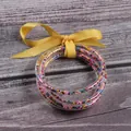 Set of 5 clear silicone bracelets with colorful seed beads and a yellow ribbon bow - 5 Pieces / Mixed Beads Yellow