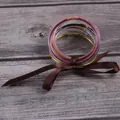 Set of 7 glitter-filled jelly bangles tied with a brown satin ribbon. - Multicolor