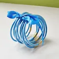 Detailed shot of nine blue glitter-filled PVC jelly bangles tied with a blue silk ribbon - 9 Pieces Set / Sky Blue