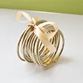 Detailed view of nine gold glitter jelly bangles tied with a decorative cream ribbon bow - 9 Pieces Set / Light gold