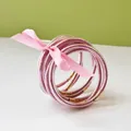 Close-up of sparkling pink glitter jelly bangles tied with a decorative ribbon bow. - 9 Pieces Set / Pink