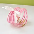 Close-up of 9-piece pink glitter jelly bangles tied with a decorative white ribbon bow - 9 Pieces Set / Deep Pink