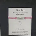 Handgefertigtes rosa geflochtenes Armband mit TEACH-Metallanhänger auf Lehrer-Segenskarte - TEACH Buchstaben-Stil / Rosa