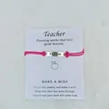 Rosa geflochtenes Lehrer-Wunscharmband mit graviertem Teach-Metallstab auf Karte - TEACH Buchstaben-Stil / Fuchsia