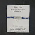Blaues geflochtenes Wachskordelarmband auf Karte für Lehrer mit Gravur TEACH - TEACH Buchstaben-Stil / Saphirblau