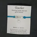 Blaues Lehrer-Wunscharmband mit graviertem TEACH-Schild und einer Geschenkkarte. - TEACH Buchstaben-Stil / Blaugrün