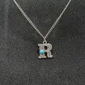 Detailed view of a retro silver necklace featuring a turquoise inlaid letter R pendant - Letter R