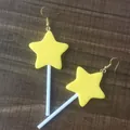 Detailopname van schattige gele ster lolly oorbellen op houten achtergrond - Geel