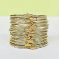 Primo piano di 10 bracciali jelly con glitter oro ed eleganti fermagli in metallo a loto. - Confezione da 10 / Oro chiaro