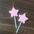 Close-up van schattige handgemaakte roze ster lolly oorbellen op een houten achtergrond. - Roze