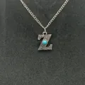 Detailed macro shot of vintage silver Z initial pendant featuring a centered turquoise stone - Letter Z