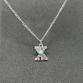 Close-up detail of a vintage silver chain necklace featuring a turquoise initial X pendant - Letter X