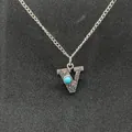 Detailed macro view of retro silver initial V necklace with turquoise stone inlay - Letter V