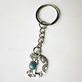 Detailed view of a vintage silver letter D keychain with turquoise and western engravings. - Letter D