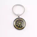 Detailed macro view of a Norse Viking Vegvisir runic compass keychain with glass cabochon finish - Golden Viking Compass / Silver
