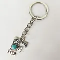 Close-up of retro silver letter F keychain with turquoise stone and floral patterns - Letter F