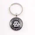 Close-up of Viking Valknut symbol and Norse runes on black circular keychain pendant - Interlocked Valknut / Silver
