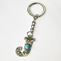 Close-up of vintage silver letter J keychain with turquoise and engraved patterns - Letter J