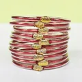 Stack of ten red glitter filled PVC jelly bangles with golden lotus buckle charms - 10 Pieces Pack / Red
