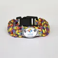 Close-up of a colorful braided paracord bracelet with an Autism Strong puzzle heart charm - Strong