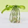 Close-up detail of 5-layer green glitter silicone bangle bracelets with silk ribbon bow - 5 Pieces / Avocado Green
