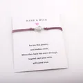 Vue détaillée d'un bracelet de vœux avec breloque tortue monté sur une carte cadeau - Bordeaux
