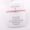 Vue détaillée du bracelet tortue rose monté sur une carte de vœux Make a Wish personnalisée - Rouge pastèque