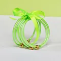 Macro view of five green glitter-filled silicone tube bangles tied with a ribbon - 5 Pieces / Fluorescent Green
