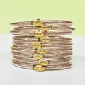 Vue détaillée des bracelets à paillettes en silicone à 9 couches avec boucles lotus - Pack de 9 Pièces / Or rose
