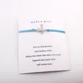 Détail du bracelet en cordon bleu avec breloque tortue sur une carte de vœux Make a Wish - Bleu ciel