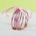 Detailed view of the 5-layer pink glitter silicone bangles set tied with a silk ribbon - 5 Pieces / Pink