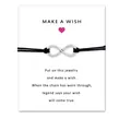 Macro view of infinity symbol bracelet on white wish card with blessing text info. - Infinity Symbol (EB0168) / Black