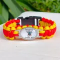 Detail van rood en geel paracord armband met een Class of 2024 afstudeerbedeltje - Oranjerood