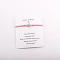 Vue détaillée d'un bracelet de vœux tortue rose sur une carte de présentation Make a Wish - Orange