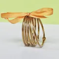 5-piece silicone gold glitter bangles set featuring an orange decorative ribbon bow - 5 Pieces / Gold