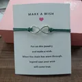 Detail view of the infinity symbol wish bracelet attached to a motivational gift card - Infinity Symbol (EB0168) / Dark Green