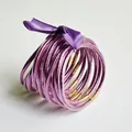 Set van 10 paarse glitter jelly armbanden vastgebonden met een bijpassende strik - Lichtpaars
